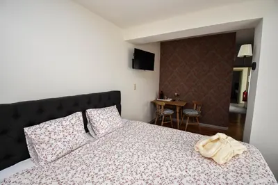 a bedroom with a large bed and a table at B&B De Bloesem in Hoeselt