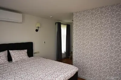 a bedroom with a bed and a wall at B&B De Bloesem in Hoeselt
