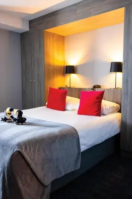 a hotel room with a large bed with red pillows at Van der Valk Hotel Liège Congres in Liège