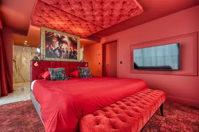 a red bedroom with a red bed and a red couch at Van der Valk Hotel Liège Congres in Liège
