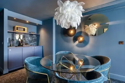 a dining room with a glass table and blue chairs at Van der Valk Hotel Liège Congres in Liège
