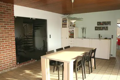 a kitchen with a wooden table and chairs at B&B Le Jardin d'Epicure in Olne