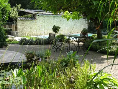 a patio with a table and chairs in a garden at De Epicurist in Hasselt