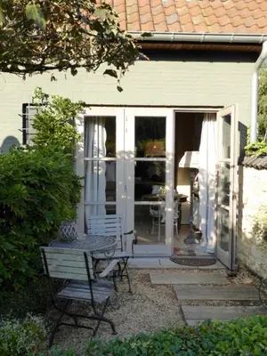 a patio with a table and a chair in front of a house at De Epicurist in Hasselt