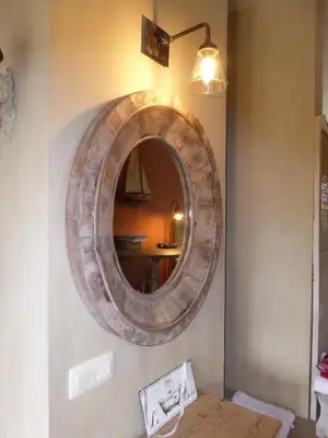 a mirror hanging on a wall with a wooden table at De Epicurist in Hasselt