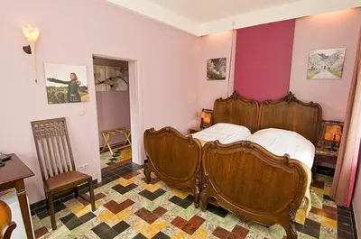 a bedroom with a wooden bed and two chairs at Het Pachthof in Borlo
