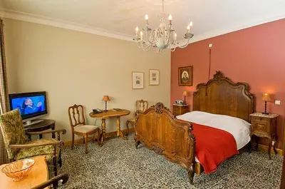 a bedroom with a bed and a table and a chandelier at Het Pachthof in Borlo