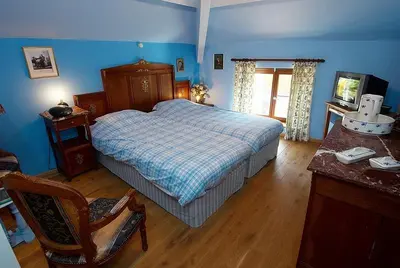 a bedroom with a bed and a chair in it at Het Pachthof in Borlo