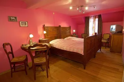 a bedroom with a bed and a table and chairs at Het Pachthof in Borlo