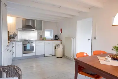 a kitchen with white appliances and a wooden table at Bellevue Maison de Greunebennet in Plombières