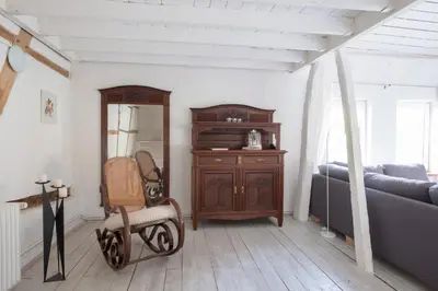 a bedroom with a bed and a chair and a dresser at Bellevue Maison de Greunebennet in Plombières