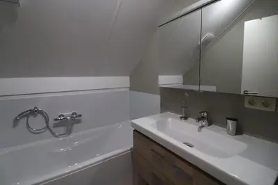 a white bathroom with a sink and a mirror at Stefjes Holiday Home in Dilsen-Stokkem