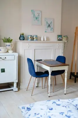 a dining room with a table and two blue chairs at Gastenkamers In de Bleick in Rekem