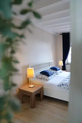 a bedroom with a bed and a table with a lamp at Gastenkamers In de Bleick in Rekem