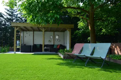 a picnic table and two chairs in a yard at B&B Maris Logies in Hasselt