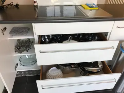a kitchen with white drawers and a counter at Vakantiehuis Piantho in Overpelt