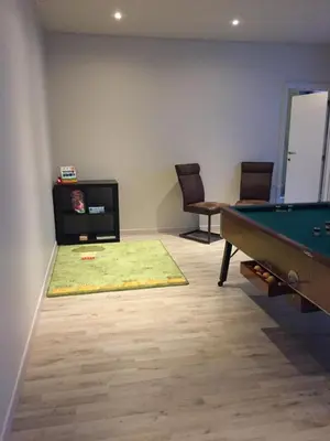a living room with a pool table and a tv at Vakantiehuis Piantho in Overpelt