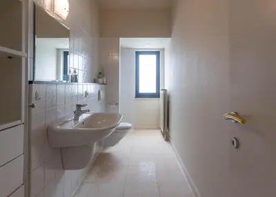 a white bathroom with a sink and a toilet at Vakantiehuis Piantho in Overpelt