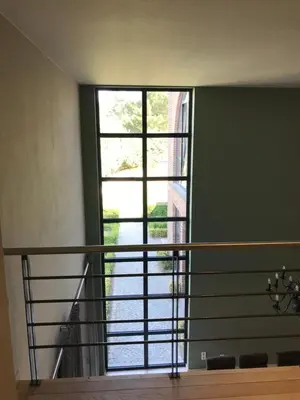 a room with a staircase with a large window at Vakantiehuis Piantho in Overpelt