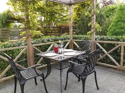 a table and chairs sitting on a patio with an umbrella at B&B Secret Garden Adults only in Voeren