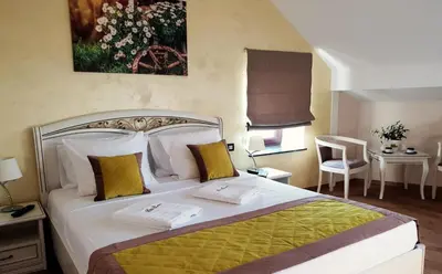a bedroom with a large bed with yellow and white pillows at B&B Secret Garden Adults only in Voeren