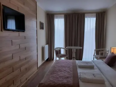 a hotel room with a bed and a tv on a wall at B&B Secret Garden Adults only in Voeren