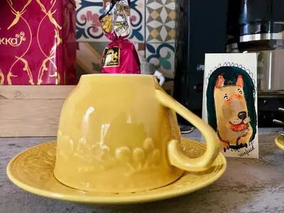 a yellow cup on a yellow plate on a table at Staying with the artist in Teuven