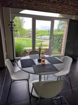 a table and chairs in a room with a window at Gite des étangs à Montzen in Plombières