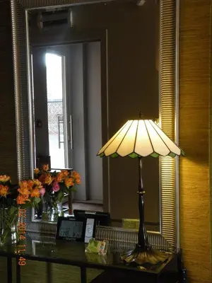 a lamp on a table in front of a mirror at B&B de Taller-Hoeve in Maasmechelen