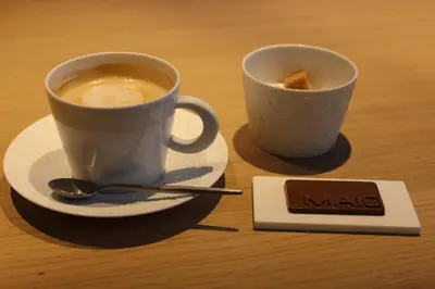 two cups of coffee sitting on a table next to a plate at MAIO B&B en Dinner in Zonhoven