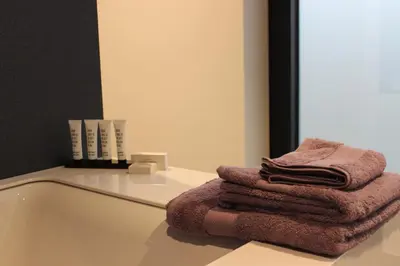 a pile of towels sitting on a counter next to a mirror at MAIO B&B en Dinner in Zonhoven