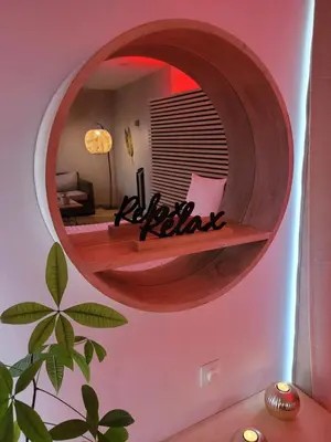 a circular mirror in a living room with a couch at La bulle D'orée in Chaudfontaine
