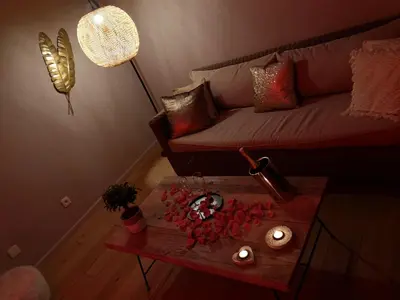 a living room with a couch and a table with candles at La bulle D'orée in Chaudfontaine