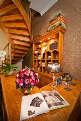 a desk with a book and flowers and a lamp at Boutique Hotel Caelus VII in Tongeren