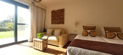 a bedroom with a bed and a couch and a window at B&B 't Goedhof in Maaseik
