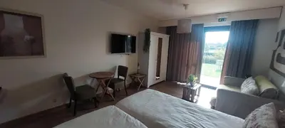 a hotel room with a bed and a table and chairs at B&B 't Goedhof in Maaseik