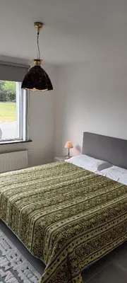 a bedroom with a large bed with a comforter at Casa Roman - nieuwe vakantiewoning - Deluxe 4p - Relax 4p - Comfort 4p -- ---Cosy 2p in Zonhoven