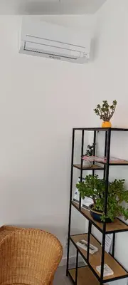 a shelf with a plant on it next to a chair at Casa Roman - nieuwe vakantiewoning - Deluxe 4p - Relax 4p - Comfort 4p -- ---Cosy 2p in Zonhoven