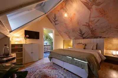 a bedroom with a large bed with a painting on the wall at B&B Woods and Wine in As