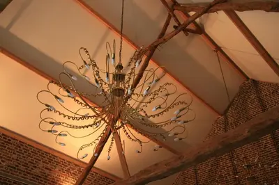 a chandelier hanging from a ceiling in a room at Hotel Oude Eycke in Maaseik