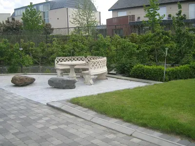 two stone benches sitting in a park with a grass at Hotel Oude Eycke in Maaseik
