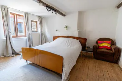 a bedroom with a large bed and a chair at Appartement atypique - coeur historique de Liège in Liège