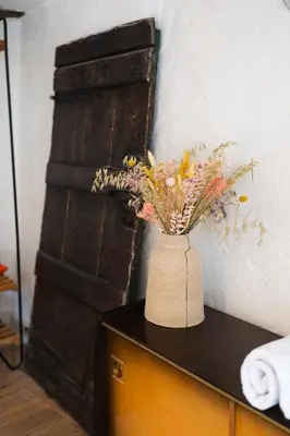 a vase filled with flowers on top of a table at Appartement atypique - coeur historique de Liège in Liège