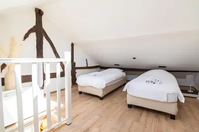 two beds in a room with a staircase at Appartement atypique - coeur historique de Liège in Liège