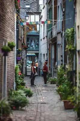 two women walking down a street in an alley at Appartement atypique - coeur historique de Liège in Liège