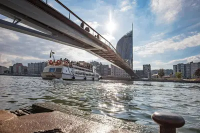 a boat traveling under a bridge on a river at Appartement atypique - coeur historique de Liège in Liège