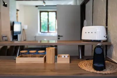 a table with a toaster and a remote control on it at Appartement atypique - coeur historique de Liège in Liège