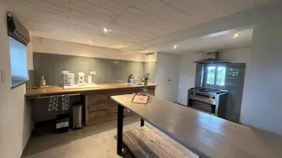 a large kitchen with a bench in the middle of it at Bed & Bets! in Geetbets