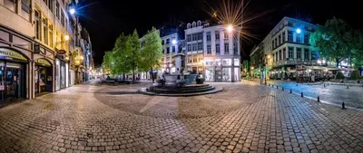 a city street at night with a fountain in the middle at Studio des princes in Liège