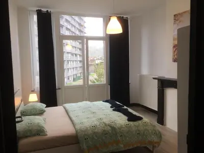 a bedroom with a bed in front of a window at Leonard room in Liège